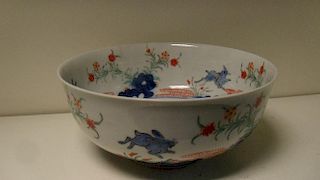 A 19th century Kakiemon style bowl painted with overglaze blue hares leaping over underglaze blue ro