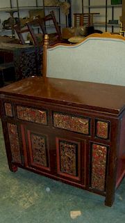 A 19th century brown lacquer side cabinet, the rectangular top above pairs of drawers and doors carv