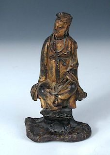 A Ming gilt bronze figure of a sage, the robed figure sits on a rock his left hand in a mudra as he