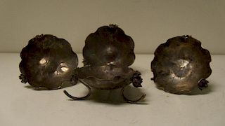 Four unmarked silver lotus leaf pickle dishes, each supported on three flower topped stems, 7cm (2.7
