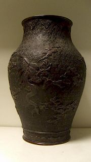 A late 19th/early 20th century bronze vase cast with a dragon amongst clouds on one side and a bird