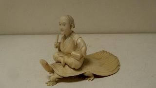 An early 20th century ivory minogame group, the long tailed turtle like animal with inlaid eyes supp