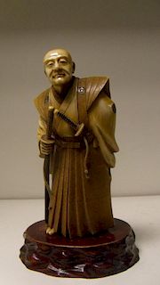 An early 20th century ivory figure of a samurai, the grey haired man wears a daisho with his formal