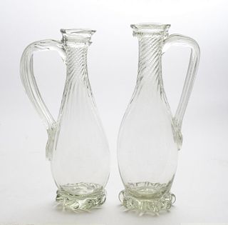 PAIR OF BLOWN GLASS SPIRAL-FLUTED PEAR-FORM EWERS AND A SIMILAR GREEN GLASS EWER
