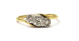 A gold three stone diamond crossover ring,