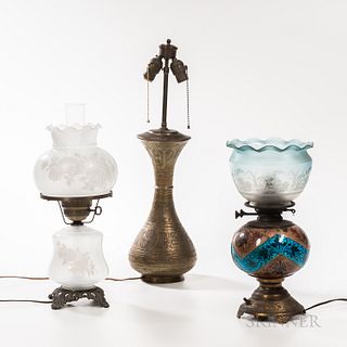 Three Table Lamps, all electrified; two gilt-metal and earthenware, one with porcelain body with mythical masks among scrolled foliage