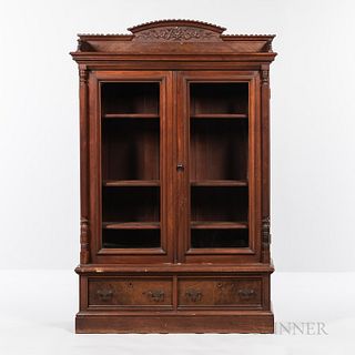 Victorian Walnut Library Cabinet, America, 19th century, with carved floral arched crest and column sides, pair of glass-front doors ab
