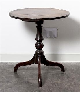 * An American Walnut Tripod Table Height 27 1/4 x diameter 24 3/4 inches.