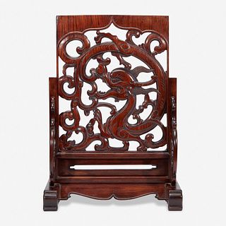 A Chinese carved and pierced huanghuali "dragon" panel, in later hardwood stand 黄花梨镂雕龙纹木板 后配底座 The panel late Ming/Qing dynasty 木板为明或清
