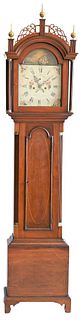 Peregrine White Cherry Tall Case Clock having fretwork top with three finials over tombstone door, flanked by fluted columns, over arched molded door 