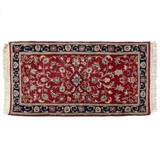 Tapete. India, SXX. Elaborado en fibras de lana. Decorado con elementos florales y orgánicos en color beige, azul, rojo.