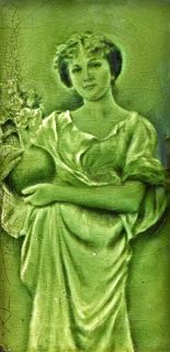 A GREEN-GLAZED MAJOLICA PICTURE TILE, CIRCA 1900, depicting a lady holding 
