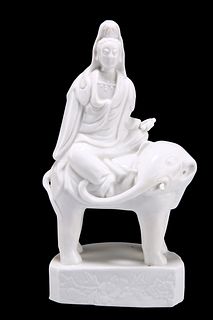 A RARE CHINESE BLANC DE CHINE MODEL OF A GUANYIN SEATED ON THE BACK OF A ST
