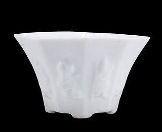 A CHINESE BLANC DE CHINE LIBATION CUP, the octagonal body moulded with the 