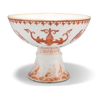 A CHINESE PORCELAIN STEM CUP, the exterior decorated in iron red with bats.