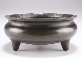 A CHINESE BRONZE TRIPOD CENSER, of compressed globular form on three conica