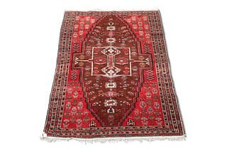 AN AFGHAN RUG, the brick red field with large stepped brown lozenge, with c