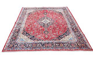 A FINELY WOVEN PERSIAN MASHAD CARPET, the red field with scrolling foliate 