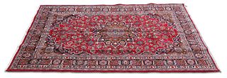 AN IRANIAN HAND-KNOTTED WOOL CARPET, MASHAD, the red field with all-over sc