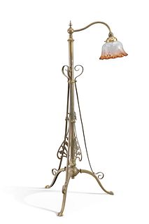 AN ART NOUVEAU BRASS TELESCOPIC STANDARD LAMP, raised on a tripod base, wit