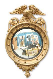 A 19TH CENTURY GILTWOOD CONVEX MIRROR, with eagle crest and reeded slip. 62