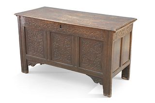 A 17TH CENTURY OAK COFFER, with lunette carved rail above a three-panel fro