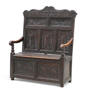 A VICTORIAN CARVED OAK BOX SETTLE, the carved and fielded back above downsw