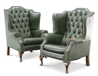 A PAIR OF GREEN LEATHER BUTTON-BACK WING-BACK ARMCHAIRS, each with short ca