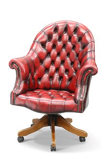 AN OXBLOOD LEATHER DEEP BUTTONED SWIVEL DESK CHAIR, with high arched back a