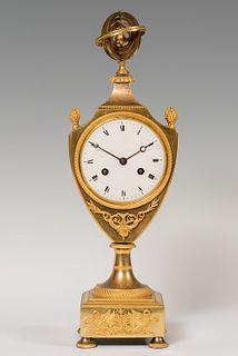 Clock; France, Empire period, circa 1805. 
Mercury gilt bronze. 
Paris type movement. 
It has a pendulum and no key. 
Measures: 42 x 12 x 12 cm.