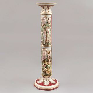 Columna. Italia, sXX. Elaborada en porcelana Capodimonte. Decorada con amorcillos, esmalte dorado, motivos vegetales. 96 cm de altura.