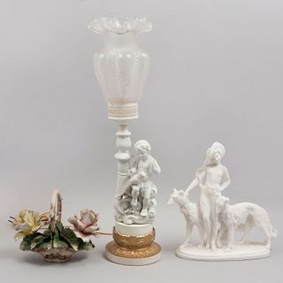 Lote mixto de 3 piezas. SXX. Elaboradas en porcelana, resina y pasta. Consta de: lámpara, bouquet y niña con perros.