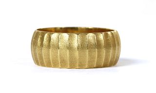 An 18ct gold patterned ‘D’ section wedding ring,