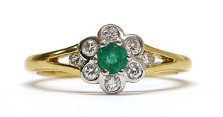 An 18ct gold emerald and diamond daisy cluster ring,