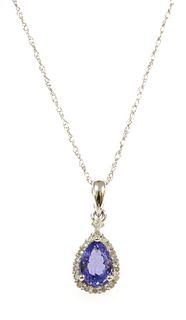 A white gold tanzanite and diamond halo cluster pendant,