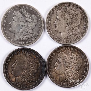 Four Morgan silver dollars, 1884-S, 1894-O, etc.