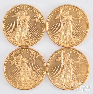 Four 1/4ozt fine gold American Eagle coins.