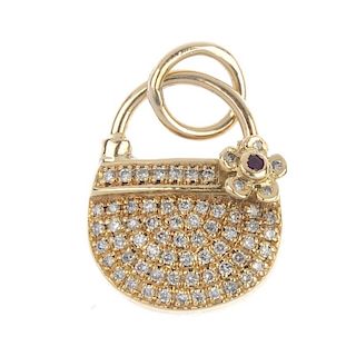 A diamond charm. Designed as a pave-set diamond handbag, with red gem floral accent. Estimated total
