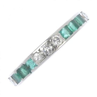 A mid 20th century platinum emerald and diamond full-circle eternity ring. Set with a series of alte