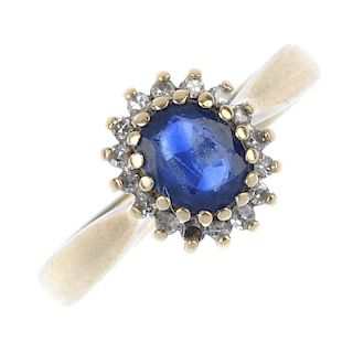 A 9ct gold sapphire and diamond cluster ring. The oval-shape sapphire, within a single-cut diamond s