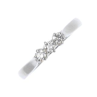 A platinum diamond three-stone ring. The brilliant-cut diamond line, to the plain band. One diamond