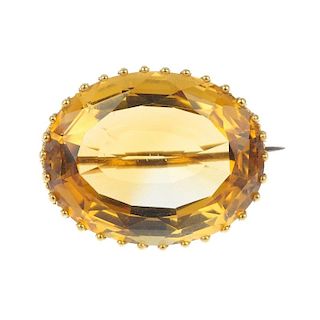 A citrine single-stone brooch. The oval-shape citrine, to the scrolling surmount. Length 2.5cms. Wei