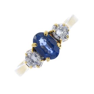 An 18ct gold sapphire and diamond three-stone ring. The oval-shape sapphire. between brilliant-cut d
