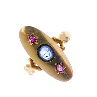 An early 20th century sapphire and ruby dress ring. The circular sapphire cabochon, with circular-sh