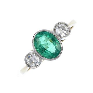 An emerald and diamond three-stone ring. The oval-shape emerald, with old-cut diamond shoulders. Est