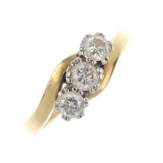 An 18ct gold diamond three-stone ring. The brilliant-cut diamond diagonal line, to the asymmetric sh