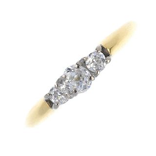 An 18ct gold diamond three-stone ring. The old-cut diamond, with similarly-cut diamond sides, to the