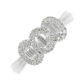 An 18ct gold diamond cluster ring. Comprising thee baguette-cut diamonds, within a brilliant-cut dia