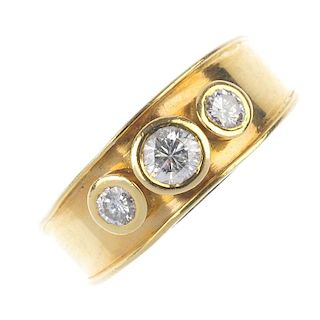 An 18ct gold diamond three-stone ring. The slightly graduated raised brilliant-cut diamond collets,