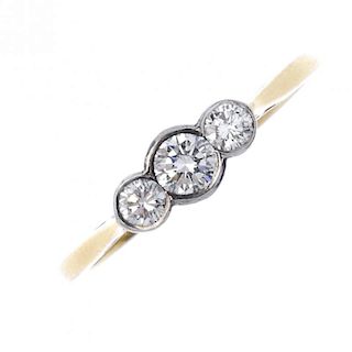 An 18ct gold diamond three-stone ring. The graduated brilliant-cut diamond line, within a shared col